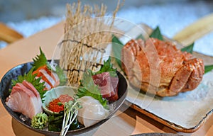 Mixed sliced fish sashimi on ice in bowl