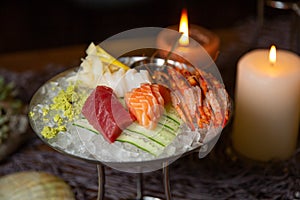 Mixed sliced fish sashimi and shrimps on ice in black bowl. Sashimi Salmon Tuna Hamachi Prawn and Surf Calm set, raw fish, japanes