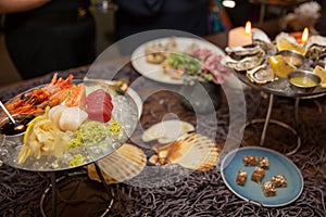 Mixed sliced fish sashimi and shrimps on ice in black bowl. Sashimi Salmon Tuna Hamachi Prawn and Surf Calm set, raw fish, japanes