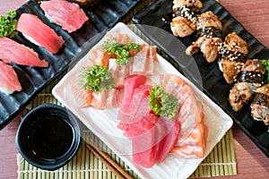 Mixed sliced fish sashimi in white plate. Sashimi Salmon and Tuna set with Tuna, flying fish roe caviar and Foie Gras closeup.