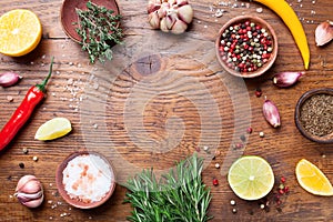 Mixed spices and fresh rosemary on wooden kitchen table top view. Ingredients for cooking. Food background.