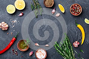 Mixed spices and herbs on black stone table top view. Ingredients for cooking. Food background.
