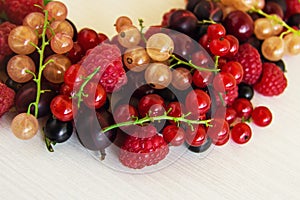 Mixed summer berries raspberry, blackcurrant, redcurrant, white currant, gooseberry, cherry on the white background.