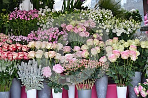 Mixed of summer flowers displayed in front of a flower shop, delicate white, pink and red roses and other decorative indoor plants