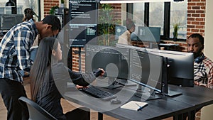 Mixed team of programmers analyzing source code pointing at screens comparing algorithm