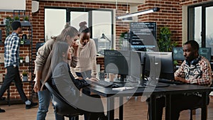 Mixed team of software engineers brainstorming ideas for new code library in front of computer screens