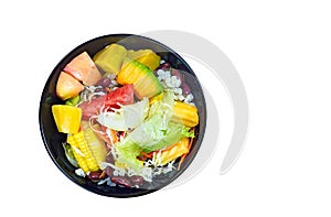 Mixed vegetable and fruit salad in black bowl