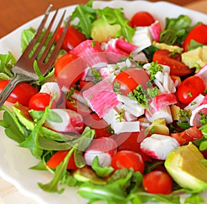 Mixed vegetable salad with crab sticks and avocado