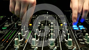 Mixer control panel at a concert, hands, worker soundman moving faders control the console.