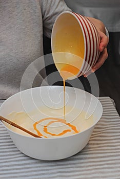 Mixing Baking Dough for Waffles, Egg Yolks and Milk, in a Glass Bowl. Food Preparing Process Photography Concept