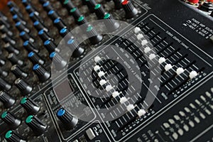 Mixing board with white and blue knobs close up