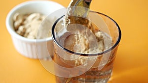 mixing brewers yeast flakes in a glass of water