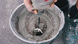 Mixing Building Cement with Water in Bucket Use Construction Mixer. Slow Motion