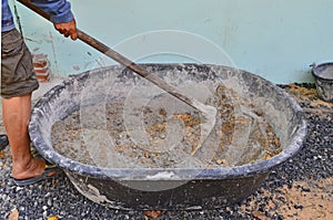 Mixing cement poder and sand by using hoe in mortar pan photo