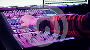 Mixing console is operated by a sound producer at audio recording studio