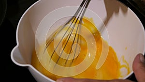 Mixing cracked eggs in a bowl. ingredient to make pancake.