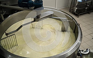 Mixing curd and whey in tank at cheese factory, top view.