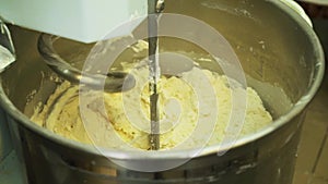 Mixing a dough for bread baking with professional kneader spiral machine at the manufacturing. Production of cookies