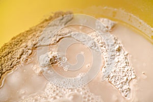 Mixing flour, dry yeast and water. Cooking dough for bread or pizza close-up