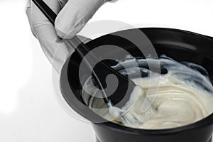 Mixing hair color in a bowl.