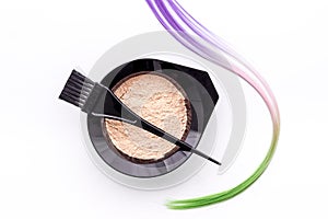 Mixing hair dye in bowl with brush and strand of hair