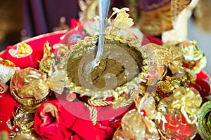 Mixing henna for hair. Natural henna color mixed pasted in a bowl. Henna the table . Golden decoration for the henna .