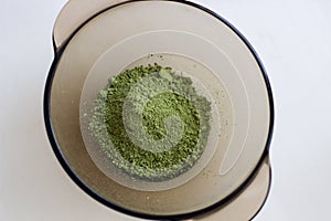 Mixing henna with a wooden spoon in a bowl for hair application of natural color like Indian henna mix