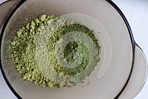 Mixing henna with a wooden spoon in a bowl for hair application of natural color like Indian henna mix