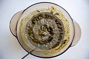 Mixing henna with a wooden spoon in a bowl for hair application of natural color like Indian henna mix