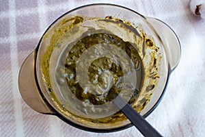 Mixing henna with a wooden spoon in a bowl for hair application of natural color like Indian henna mix