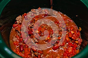 Mixing the ingredents for chili in a crock pot