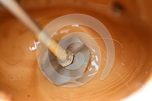 mixing milk, sugar and coffee to make a cappuccino with foam by a handheld milk frother electric mixer for coffee drink