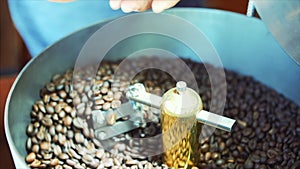Mixing of roasted coffee. Partial removal of bad grains. The roasted coffee beans got on the mixer sorting by a