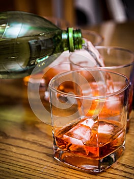 Mixing soft drink with alcohol, pouring into a glass tumbler wit