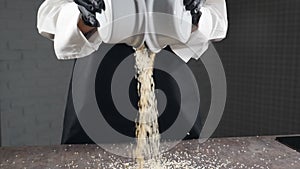 Mixing spices in slow motion. Falling white and black sesame from two white bowls. Assortment spices and herbs for