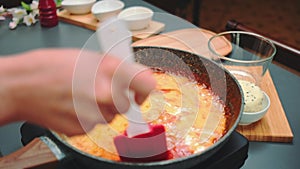 Mixing tomato sauce with egg omelet