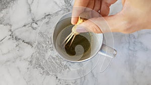 Mixing up matcha and water with the whisk