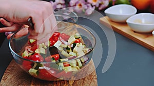 Mixing vegetable salad with a spoon