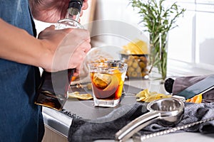 Mixologist making refreshing cocktail with vermouth at home