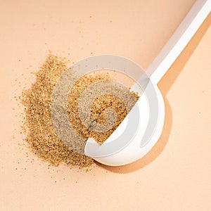 Mixture of dietary fiber supplement . White scoop of dietary fiber on a beige background. Dietary herbal supplements. Biologically