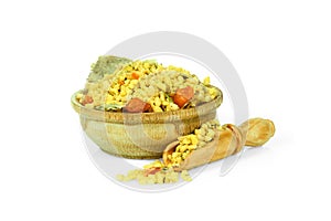 A mixture of dried vegetables in a wooden cup with a spoon for spices isolated on a white background. Collection of