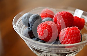 Close-up Detail of Fresh Raspberries and Blueberries in a Vintage Champagne Glass