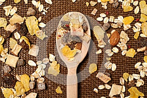 Mixture of oat flakes with fruits on a brown knitted coaster