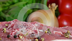 Mixture of peppers falling on lamb steak falls on a background of vegetables