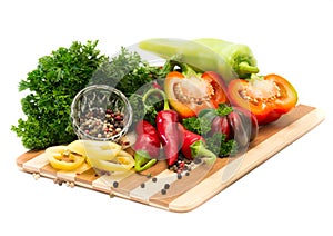 Mixture of peppers with greens on a wooden board