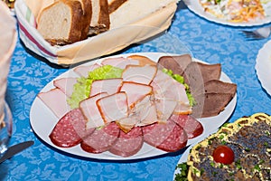 A mixture of sliced meat, sausage and ham, set the restaurant table