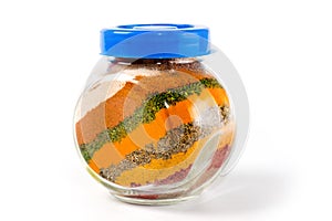 A mixture of spices in a glass jar shot close-up on a white background