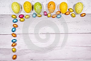 Mixtures of easter eggs of all colors and sizes on a background of old wooden boards resembling old parquet. Easter concept