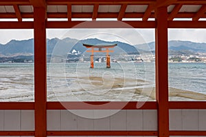 MIYAJIMA TORII GATE THROUGH RED WOODEN WINDOW,HIROSHIMA,JAPAN