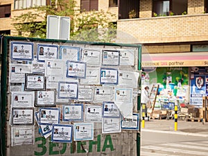 Death notices umrlice posted on a billboard in the city center of Mladenovac, indicating the recent deceased persons